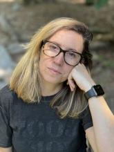MA Student Jessica Villar in a dark grey t-shirt, and wearing glasses