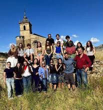 Students in Leon standing in a field and in front of a 14th century monastery.