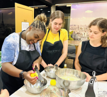 Three students in a kitchen in León, learning to cook local food. 