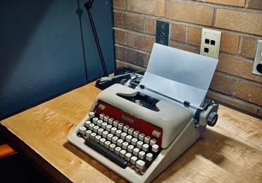 A mid-century typewriter in the chair's office, to go with those mid-century Padelford vibes (to be fair, she does use it!). Mid-century Royal typewriter on a maple and wenge desk.