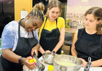 Three students in a kitchen in León, learning to cook local food. 