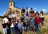 Students in Leon standing in a field and in front of a 14th century monastery.